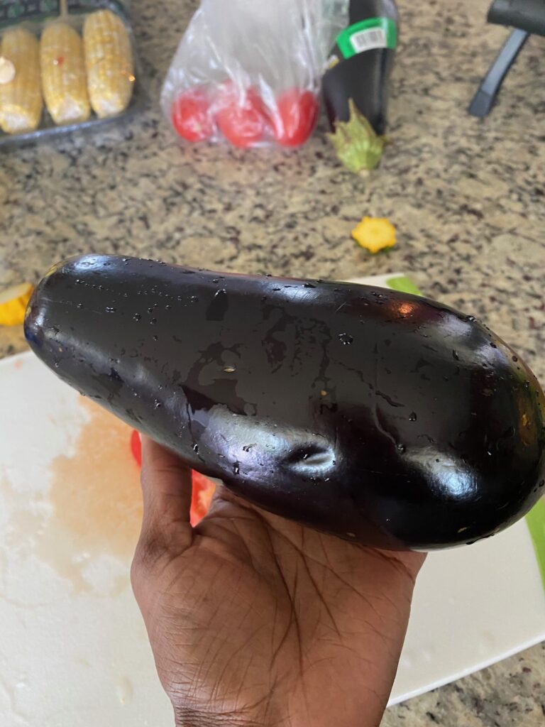 Picture of eggplant with vegetables in the background