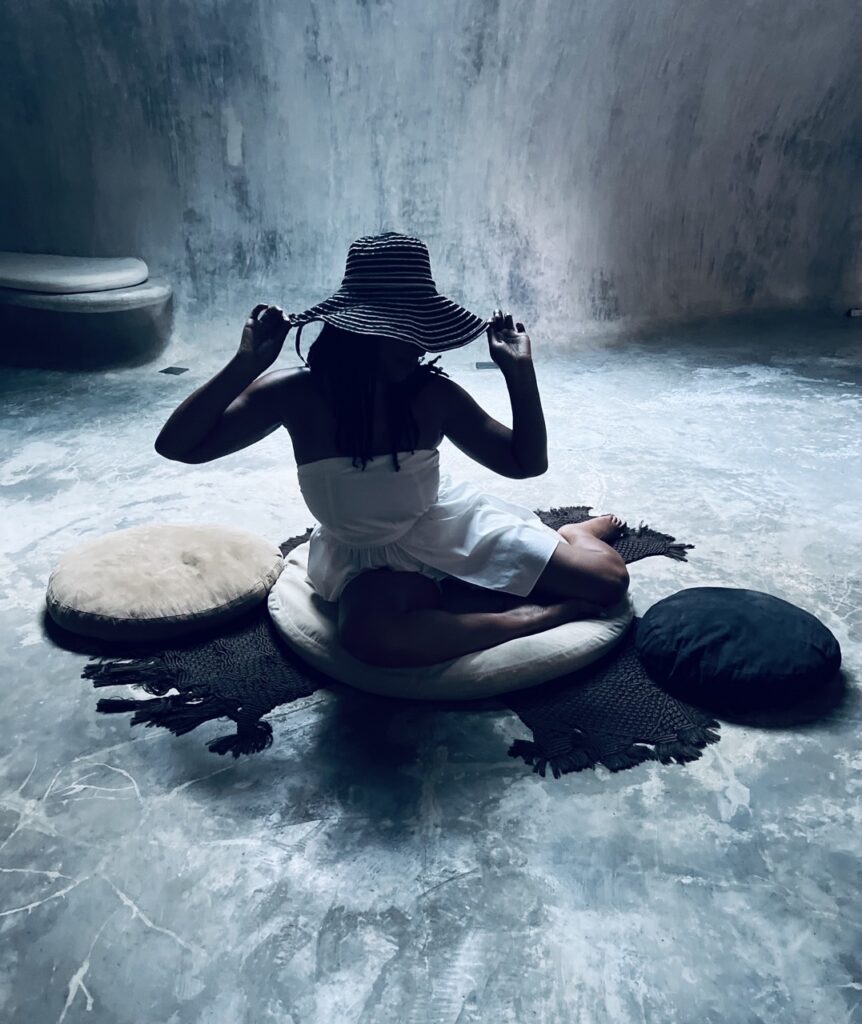 Lady sitting down with a hat on in a modeling pose
