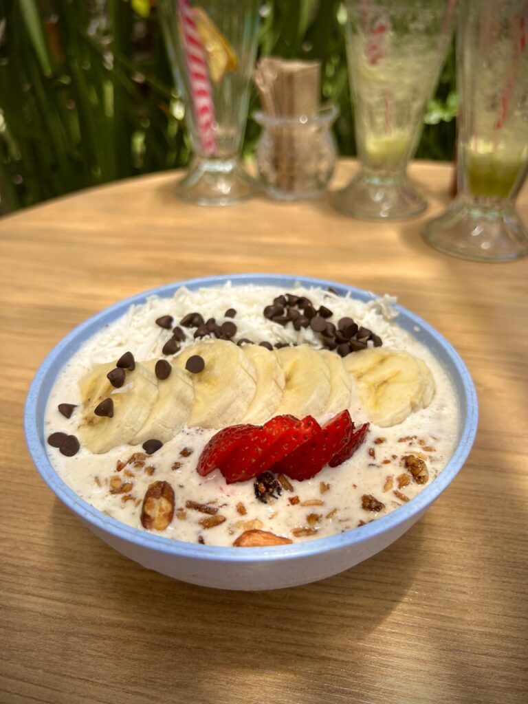 Smoothie bowl with sliced bananas, strawberries and cacao nibs