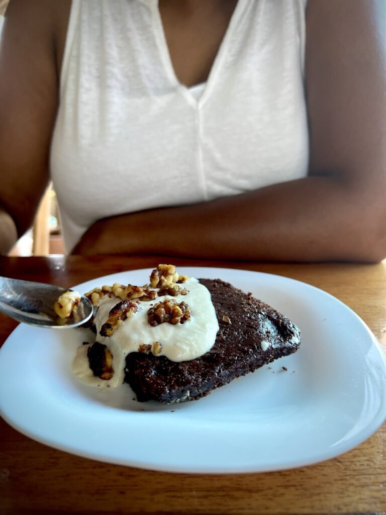 a brownie on a plate with ice cream and walnuts on top
