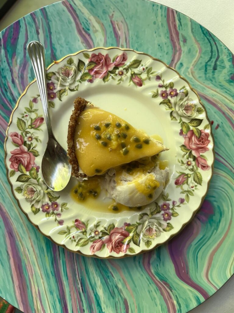 Overhead view of a plate with a slice of passionfruit cheesecake.