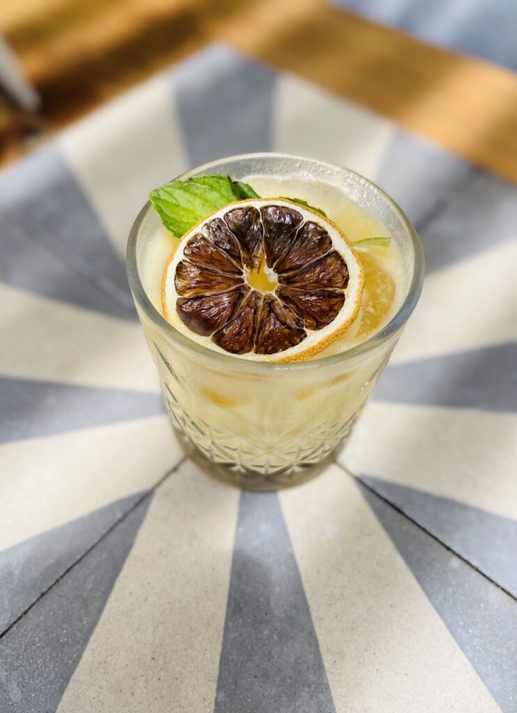 drink on table with dried blood orange on top as a garnish.