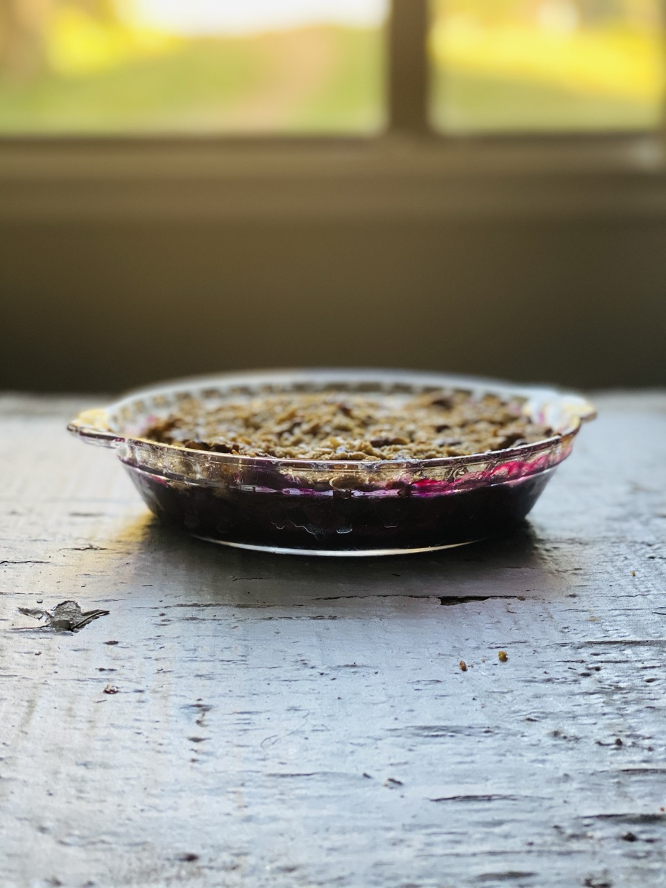 Picture of Very Berry Crisp on a table with a window in the background.