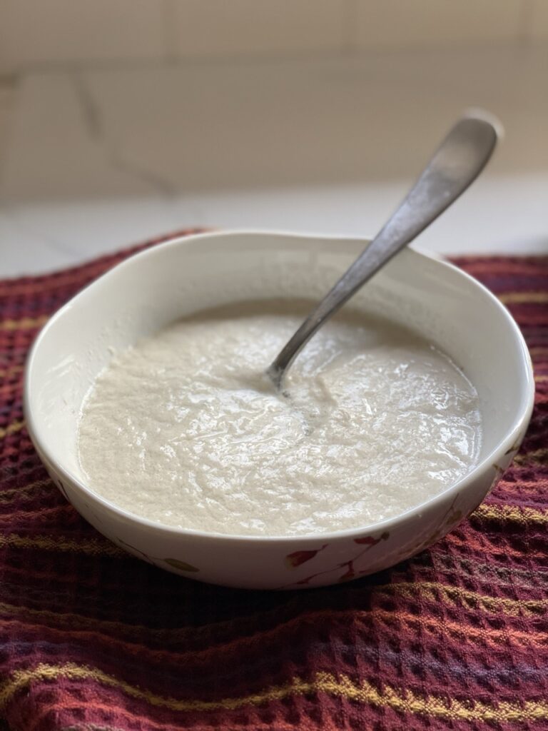 Bowl of vegan buttermilk with a spoon inside.