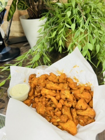 Basket of breaded and fried buffalo cauliflower bites.