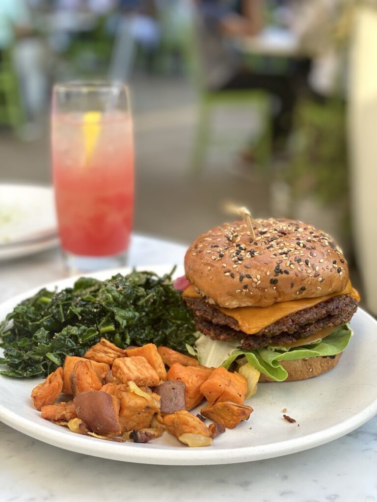 Vegan Double cheeseburger with side of kale salad and sweet potato hash