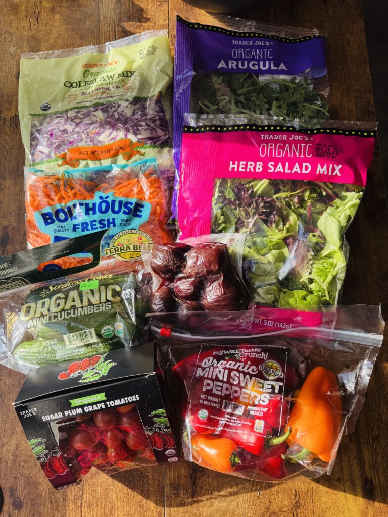 Bags of spring mix salad greens, organic arugula, organic mini cucumbers, mini sweet peppers, cooked beets and a box of sugar plum grape tomatoes.