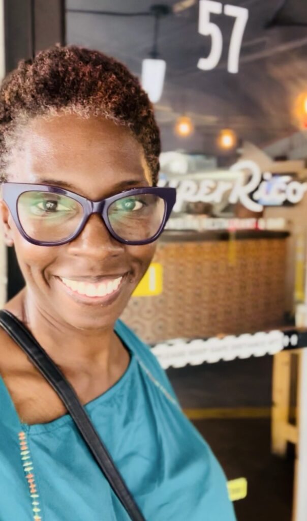 Picture of smiling woman standing  outside Super Rico Colombian Restuarant
