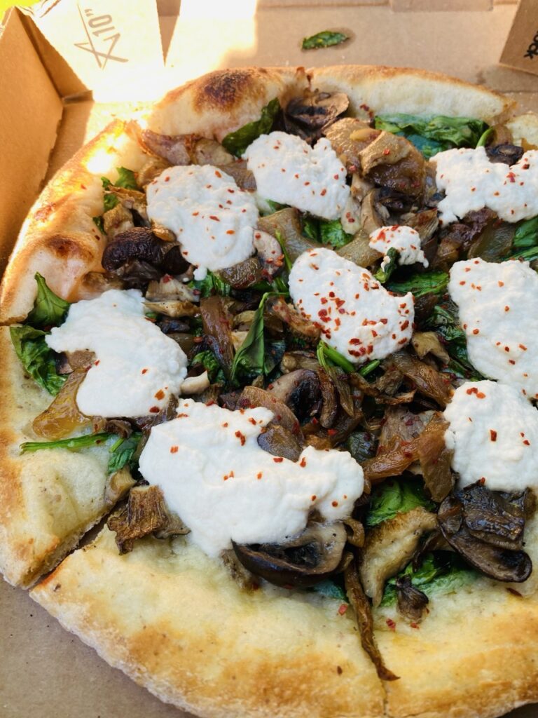Mushroom pizza with dollops of almlont ricotta on top.