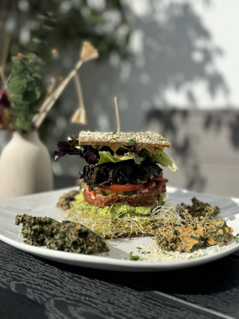 Raw hamburger served with a side of kale chips.