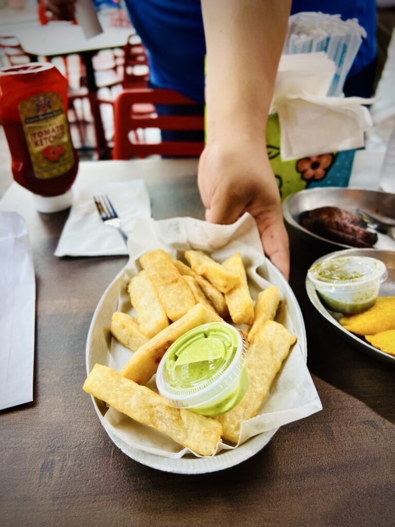 Plate of yucca fries being served with a cilantro  sauce.