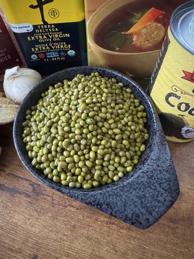 Black bowl on a marble countertop filled with dried mung beans.