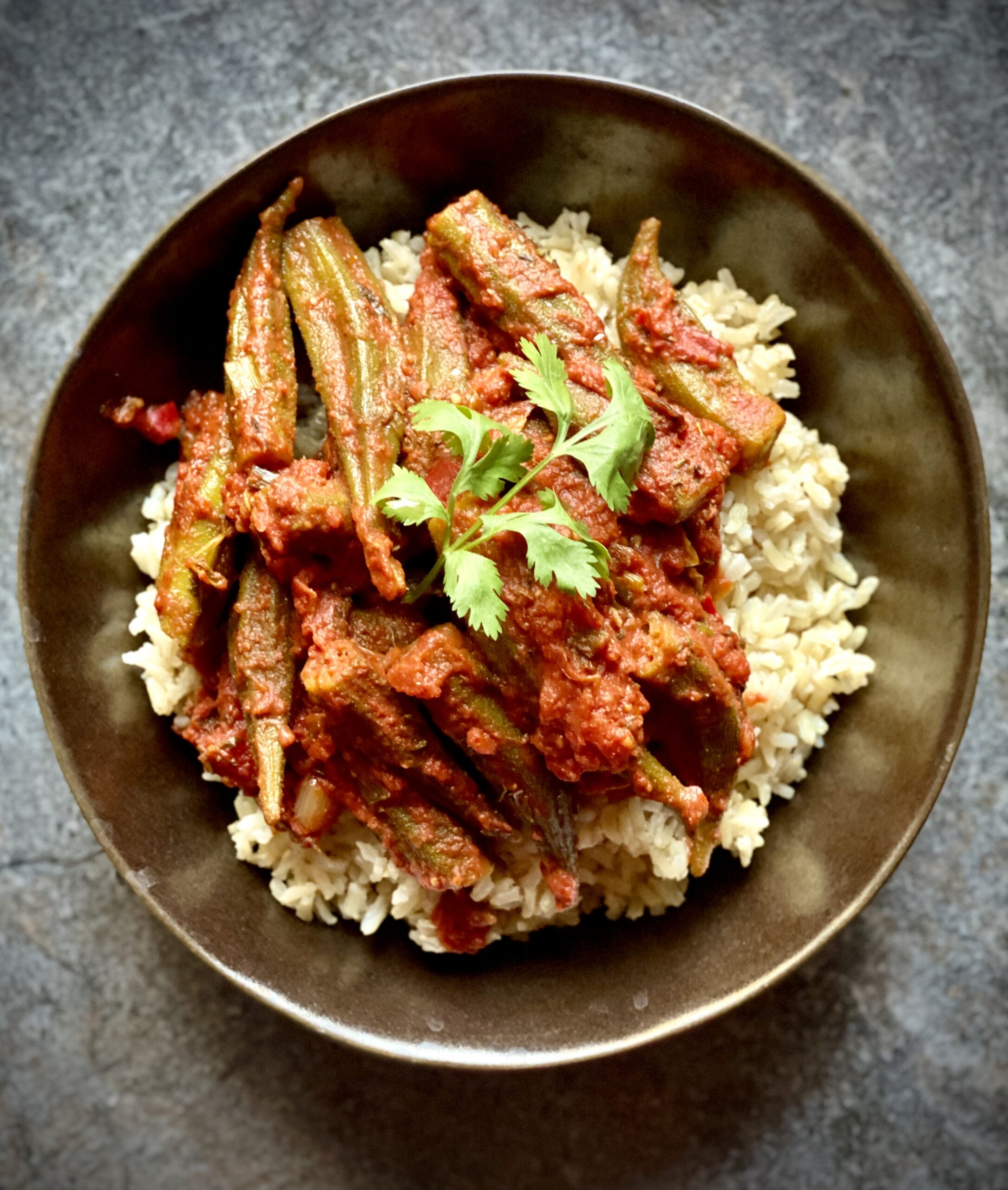 Okra cooked in tomato stew on a bed of brown rice.